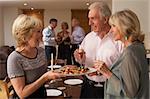 Woman Serving Hors D'oeuvres To Her Guests At A Dinner Party