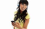 A young woman having fun is enjoying music through a portable mp3 player or similar.  White background.