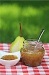 Jar of  pear jam on the table in the summer garden