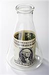 A one dollar bill in an erlenmeyer flask on a white background.