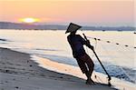 Silhouette of a fisherman on beach at sunrise