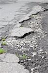 pothole road damage or pot hole concept with street