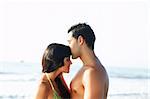 portrait of a  loving couple on the edge of  the beach. While he kisses her on the forehead