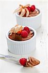 Two chocolate mousse desserts with a spoon