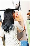 Black woman looking in fridge of modern kitchen interior