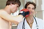 Close-up photo of a boxer punching a doctor in a face