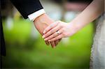 Young married couple holding hands, ceremony wedding day