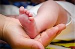 Baby's foot in his mother hand.