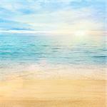 Beautiful sea background. Golden sand with blue ocean and cloudscape in the back.