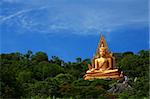 Big golden buddha on green mountain with clear sky,Rachaburi Thailand.