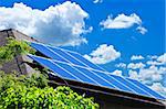 Array of alternative energy photovoltaic solar panels on roof of residential house