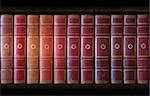 Vintage books in different shades of red and brown in bookcase