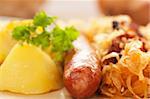 Sausage with potatoes and sauerkraut and bread loaves