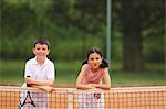 Caucasien garçon et une fille, ce qui pose de filet de tennis
