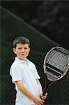 Jeune garçon tenant une raquette de Tennis