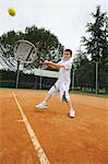 Kleiner Junge trifft Tennis-Schuss