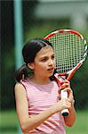 Young Girl Holding Racket And Looking Away