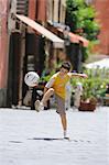 Boy Playing Soccer In Street