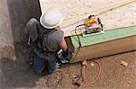 High angle view of a carpenter measuring floor panels at a construction site