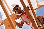 Low angle view of a carpenter marking bevel on a rafter