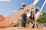 Carpenters aligning roof rafters