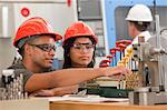 Engineering students selecting drill bits for a CNC machine