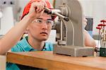 Engineering student operating a manual bench top C-frame press machine