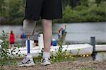 Man with a prosthetic leg standing on the dock and watching the boat race