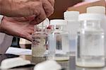 Scientist mixing chemical in sample bottles in the laboratory of water treatment plant