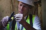 Cable installer putting connector on a wire in the cellar of a house