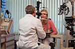 Ophthalmologist examining a woman's eyes with a slit lamp
