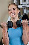 Woman exercising with dumbbells in a gym