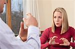 Woman signing the word 'Type' in American Sign Language while communicating with a man