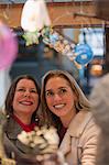 Woman looking at Christmas decorations at a store with her daughter