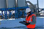 Engineer using an electronic clipboard at a materials plant