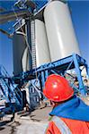 Engineer inspecting conveyor to materials silos at industrial plant