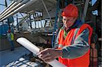 Engineer holding a blueprint at industrial plant