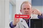 Male doctor holding no smoking sign