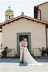 Newlyweds outside church, kissing