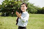 Portrait de jeune femme d'affaires touchant des bulles