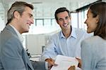 Smiling couple discussing contract with adviser