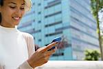 Woman with hat text messaging, low angle view