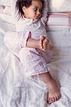 Little girl lying on bed in pajamas