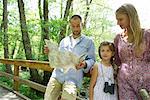 Family pausing in woods to consult map