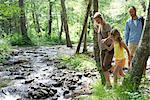 Familie Wandern entlang dem Bach im Wald