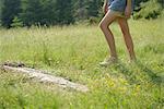 Woman walking on meadow, low section