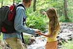 Father and daughter hiking in woods together