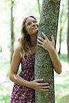 Young woman hugging tree