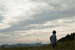 Little boy running on meadow, rear view