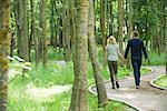 Couple walking on path in woods